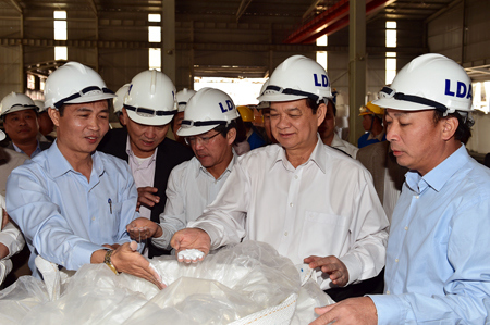Thủ tướng Nguyễn Tấn Dũng xem sản phẩm bột alumin. Nguồn: chinhphu.vn